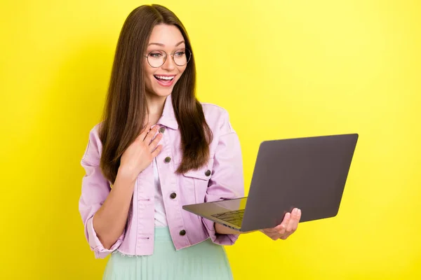 Retrato de menina alegre surpreendente atraente usando laptop assistindo vídeo cinema isolado sobre fundo de cor amarela vívida — Fotografia de Stock