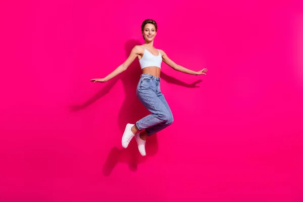 Full längd kroppsstorlek bild av ganska bekymmersfri glad flicka hoppa gott humör isolerad över ljusa rosa magenta färg bakgrund — Stockfoto