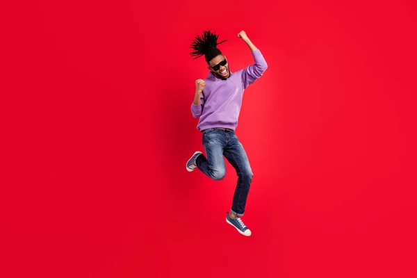 Longitud completa cuerpo tamaño foto hombre en ropa deportiva gesuring como ganador saltando aislado vívido fondo de color rojo —  Fotos de Stock