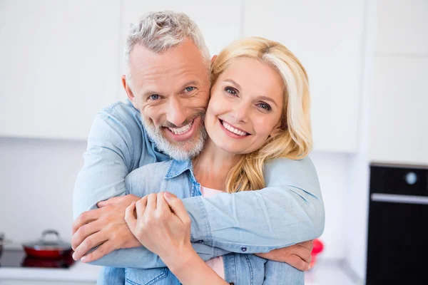 Foto de dulces amantes bastante maduros vestidos jeans camisa abrazos sonriendo en el interior habitación casa —  Fotos de Stock