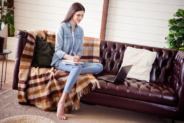 Полноразмерная фотография профиля девушки, счастливой позитивной улыбкой сидящей на диване писать заметки смотреть ноутбук удаленной работы домой — стоковое фото