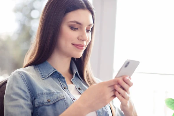 Foto av glad positiv ganska ung trevlig kvinna hålla händer ser telefon leende inomhus hus — Stockfoto