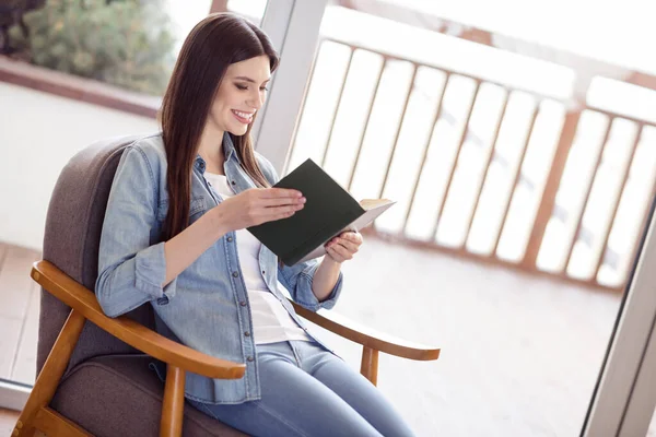 Profiel zijaanzicht portret van aantrekkelijke vrolijk gericht meisje lezen boek verblijf thuis licht wit huis binnen — Stockfoto