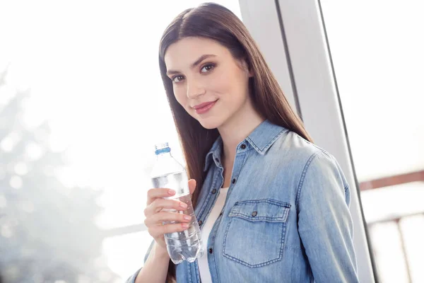 Portrait of attractive healthy calm confident girl wearing jeans drinking water staying at home light white house indoors — Stock Photo, Image