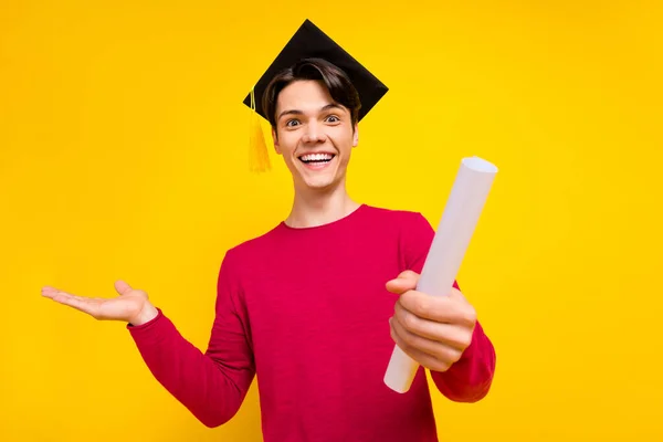 Foto de funky morena joven sujetar papel espacio vacío usar suéter rojo sombrero aislado sobre fondo de color amarillo — Foto de Stock