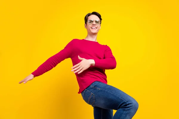 Zdjęcie uroczego funky młodego dżentelmena nosić czerwony pullover ciemne okulary taniec uśmiechnięty odizolowany żółty kolor tło — Zdjęcie stockowe