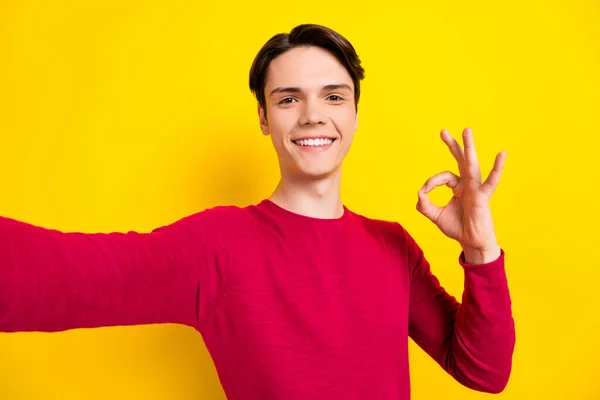 Foto di divertente brunetta ragazzo millenario fare selfie show okey indossare maglione rosso isolato su sfondo di colore giallo — Foto Stock