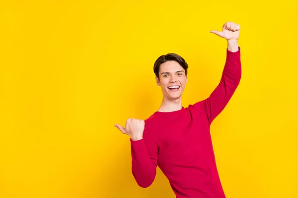 Foto di impressionato divertente giovane gentiluomo indossare pullover rosso puntando i pollici verso l'alto spazio vuoto sorridente isolato colore giallo sfondo — Foto Stock