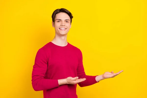 Fénykép az optimista brunet Y-generációs srác pont üres tér kopás piros pulóver elszigetelt sárga színű háttér — Stock Fotó