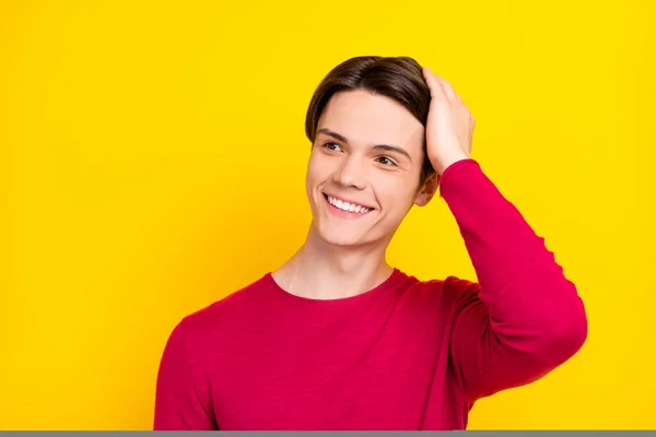 Fénykép csinos bájos fiatal úriember viselni piros pulóver kar fej keres üres tér mosolygós elszigetelt sárga szín háttér — Stock Fotó