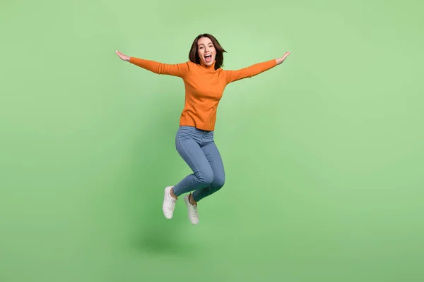 Full length body size view of attractive cheerful funky girl jumping having fun good mood isolated over green color background — Stok Foto