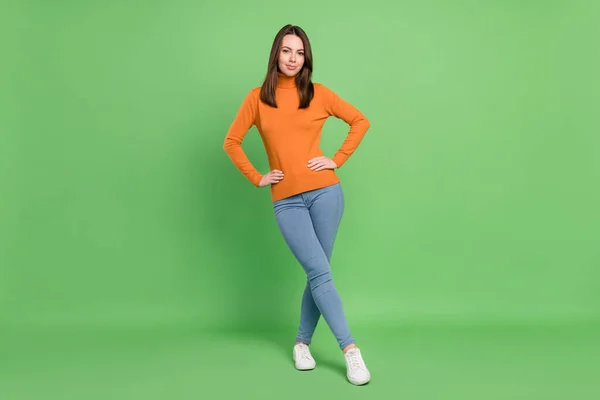 Full length body size photo girl wearing orange turtleneck jeansy uśmiechając się odizolowany pastel zielony kolor tło — Zdjęcie stockowe