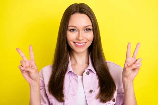 Ritratto di attraente ragazza dai capelli castani allegro che mostra v-segno buon umore isolato su sfondo di colore giallo brillante — Foto Stock