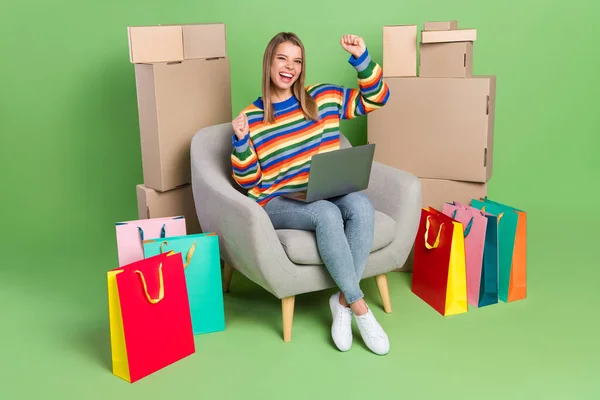 Φωτογραφία κορίτσι πορτρέτο κάθεται στην καρέκλα κάνει online ψώνια gesturing σαν νικητής απομονωμένο παστέλ πράσινο χρώμα φόντο — Φωτογραφία Αρχείου