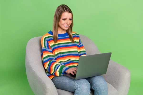 Foto retrato chica sentada en silla ropa casual navegación internet con computadora aislado pastel color verde fondo —  Fotos de Stock