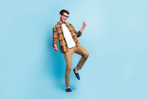 Foto de atraente muito jovem cavalheiro desgaste xadrez camisa dança sorrindo isolado azul cor de fundo — Fotografia de Stock