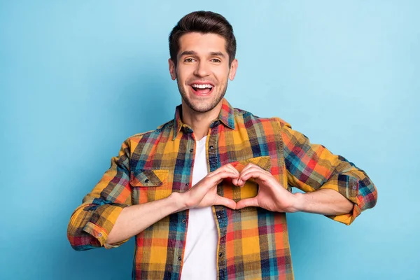 Portret van aantrekkelijke vrolijke blij verbaasde man met hart teken gezondheidszorg geneeskunde geïsoleerd over helder blauwe kleur achtergrond — Stockfoto