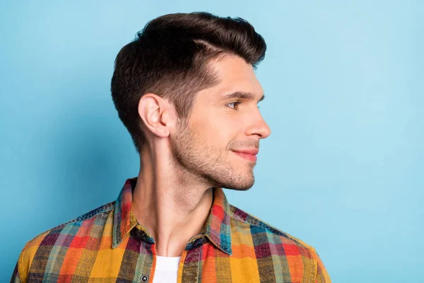 Portrait of attractive cheery well-groomed brunette guy wearing checked shirt looking aside isolated over bright blue color background — Stok Foto