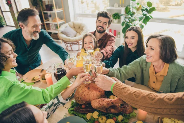 Retrato de familia alegre cuidado atractivo comiendo platos caseros tintineo jugo de champán felicitaciones en casa —  Fotos de Stock