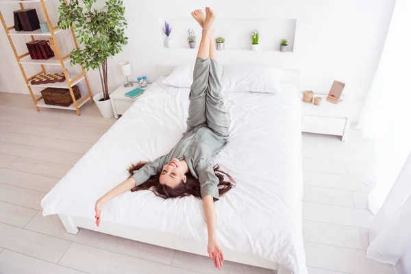 Top above high angle view portrait of attractive dreamy cheerful girl lying on bed at home house light white interior — Stock Photo, Image