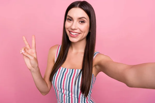 Autoritratto di attraente ragazza dai capelli castani allegro mostrando v-segno isolato su sfondo rosa color pastello — Foto Stock