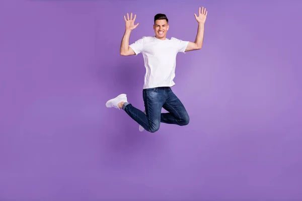 Foto de comprimento total do jovem feliz sorriso positivo tem divertido salto acenando mão Olá isolado sobre cor violeta fundo — Fotografia de Stock