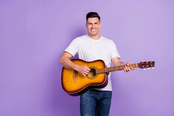 Zdjęcie młodego człowieka szczęśliwy pozytywny uśmiech grać na gitarze artysta koncert odizolowany na fioletowym tle koloru — Zdjęcie stockowe