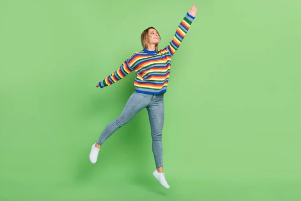 Πλήρες μήκος σώματος μέγεθος κορίτσι φωτογραφία σε πολύχρωμο πουλόβερ άλμα μέχρι απρόσεκτη παιδική απομονωμένη παστέλ πράσινο χρώμα φόντο — Φωτογραφία Αρχείου