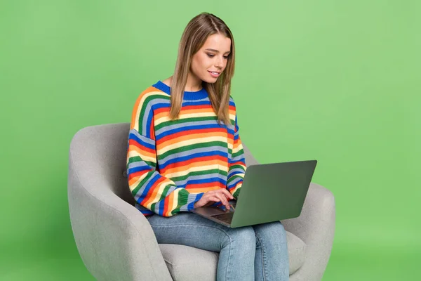 Foto retrato chica sentada en silla ropa casual trabajando en portátil aislado pastel color verde fondo —  Fotos de Stock
