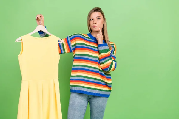 Foto Porträt Mädchen Wahl Kleid in Umkleidekabine mit Zweifel isoliert auf pastellgrünem Hintergrund — Stockfoto