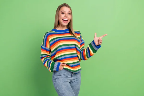 Foto Porträt lachende Mädchen mit gestreiften Pullover zeigt Leerraum erstaunt isoliert pastellgrüne Farbe Hintergrund — Stockfoto