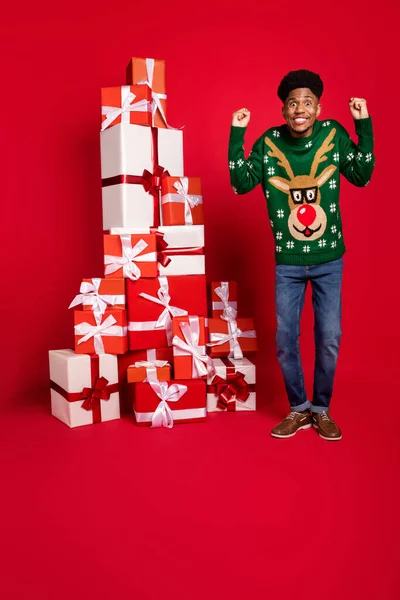 Vertical full length body size view of attractive cheerful guy with pile giftboxes having fun isolated over bright red color background — Fotografia de Stock