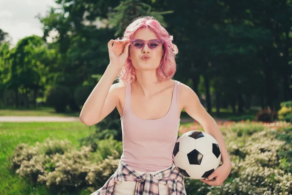 Фото молодой спортивной девушки счастливая положительная улыбка надутые губы отправить воздушный поцелуй флирт провести футбольную игру на открытом воздухе — стоковое фото