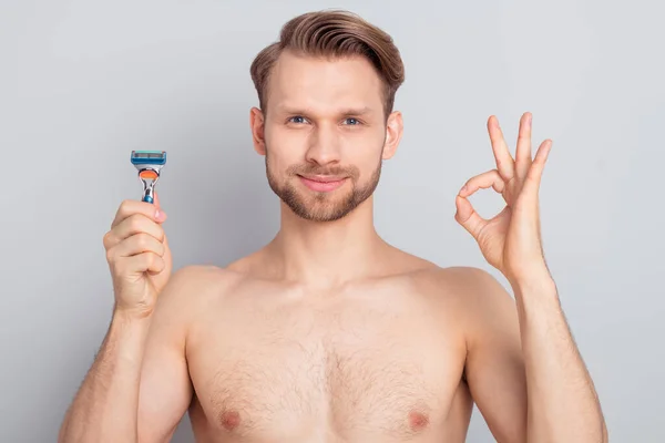 Foto van vrolijke zelfverzekerde man geen kleren lachend tonen okey scheren jukbeenderen wangen geïsoleerde grijze kleur achtergrond — Stockfoto