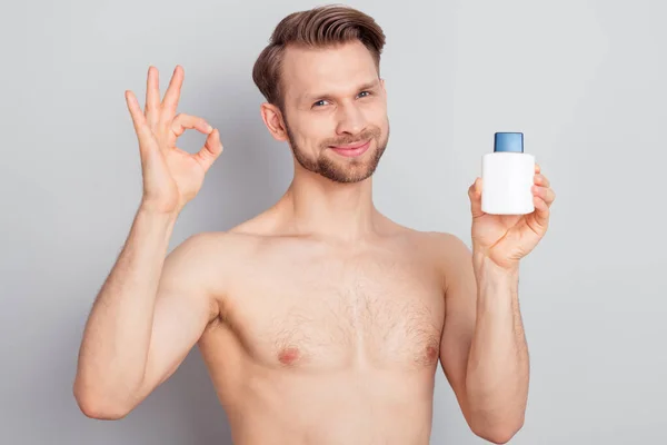 Photo of recommend young blond man hold bottle show okey sign without clothes isolated on grey color background — Stock Photo, Image