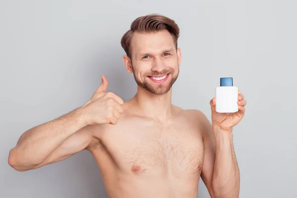 Photo of confident positive young gentleman wear nothing showing thumb up holding shaving lotion isolated grey color background — Stock Photo, Image