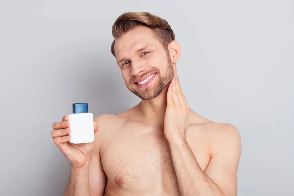 Portrait of attractive cheerful man holding in hands applying perfume hygiene isolated over grey pastel color background — Stock Photo, Image