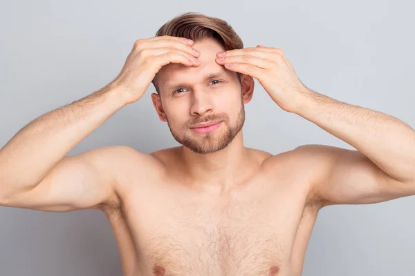 Foto av söt charmig ung gentleman bär ingenting armar huvud letar efter svarta prickar ler isolerad grå färg bakgrund — Stockfoto