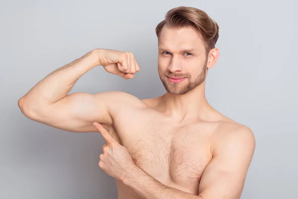 Foto van zoete schattig jong blond haar heer dragen niets wijzende vinger arm biceps glimlachen geïsoleerde grijze kleur achtergrond — Stockfoto