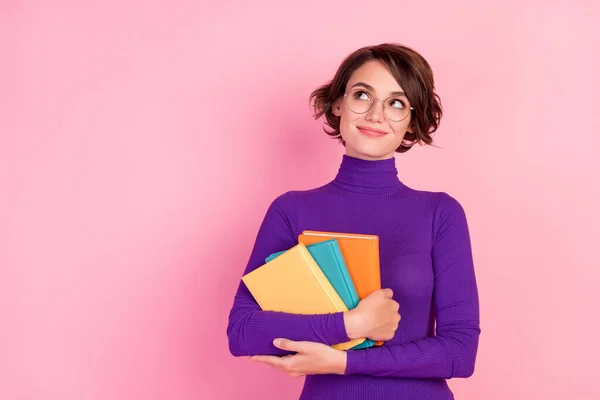 Photo of cute brunette millennial lady hold books look up wear spectacles violet pullover isolated on pink color background — Stock Photo, Image