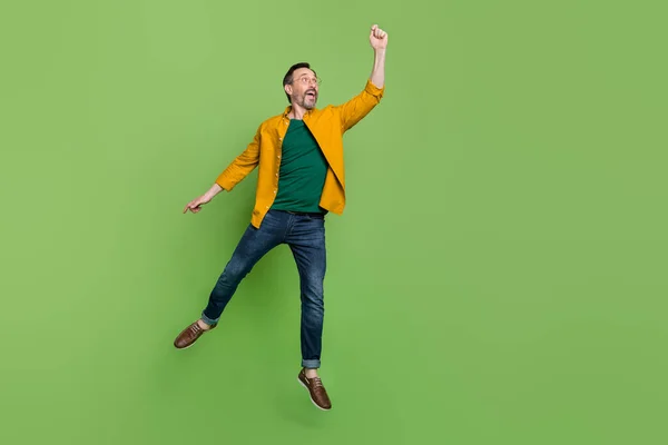Full size zdjęcie przystojny Dojrzały mężczyzna szczęśliwy pozytywny uśmiech spróbuj złapać skok parasol izolowane na zielonym tle kolor — Zdjęcie stockowe
