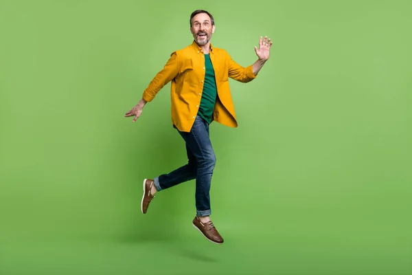 Pleine taille profil côté photo de mature homme heureux sourire positif saut aller marcher courir isolé sur fond de couleur verte — Photo