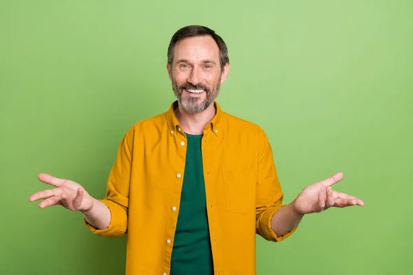 Фото зрілого гарного бізнесмена щаслива позитивна посмішка тримає руки говорити ізольовано на зеленому кольоровому фоні — стокове фото