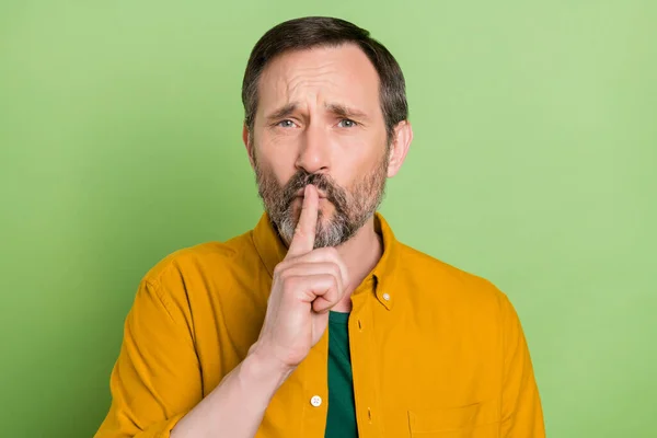 Fénykép komoly magabiztos érett férfi öltözött narancs ing ujj ajkak kérve lekapcsolása elszigetelt zöld színű háttér — Stock Fotó