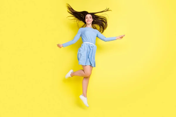 Photo de charmante jeune femme douce porter tenue pointillée sourire sautant haut isolé fond de couleur jaune — Photo