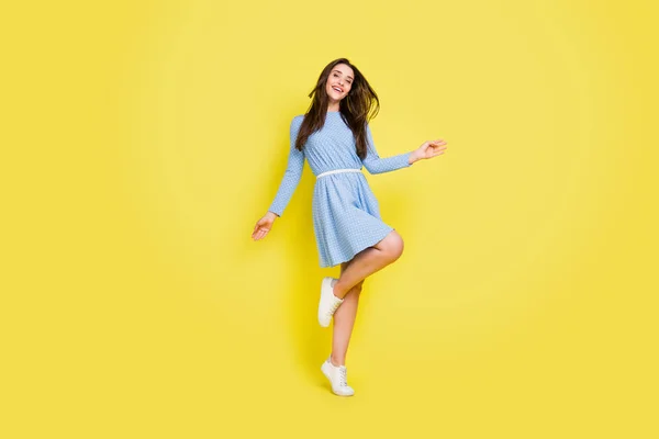 Φωτογραφία από γλυκό γοητευτικό νεαρή κοπέλα φορούν διακεκομμένη στολή χαμογελώντας χορό απομονωμένο κίτρινο χρώμα φόντο — Φωτογραφία Αρχείου