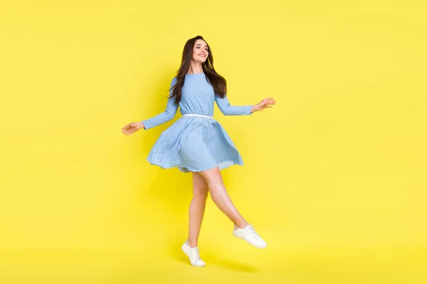 Φωτογραφία προφίλ του ανέμελη κορίτσι με τα πόδια σταθεί στις μύτες των ποδιών φορούν διάσπαρτα μπλε παπούτσια φόρεμα απομονωμένο κίτρινο χρώμα φόντο — Φωτογραφία Αρχείου