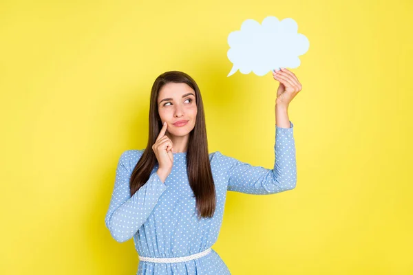 Photo of dreamy unsure young lady wear dotted outfit smiling holding looking speaking bubble empty space isolated yellow color background — Stok Foto