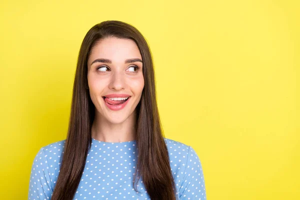 Foto van opgewonden funky jonge dame dragen gestippelde outfit glimlachen likken lippen kijken lege ruimte geïsoleerde gele kleur achtergrond — Stockfoto
