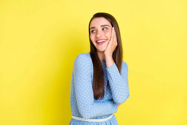 Foto de bonito engraçado jovem mulher vestida azul roupas braço bochecha olhando espaço vazio sorrindo isolado cor amarela fundo — Fotografia de Stock